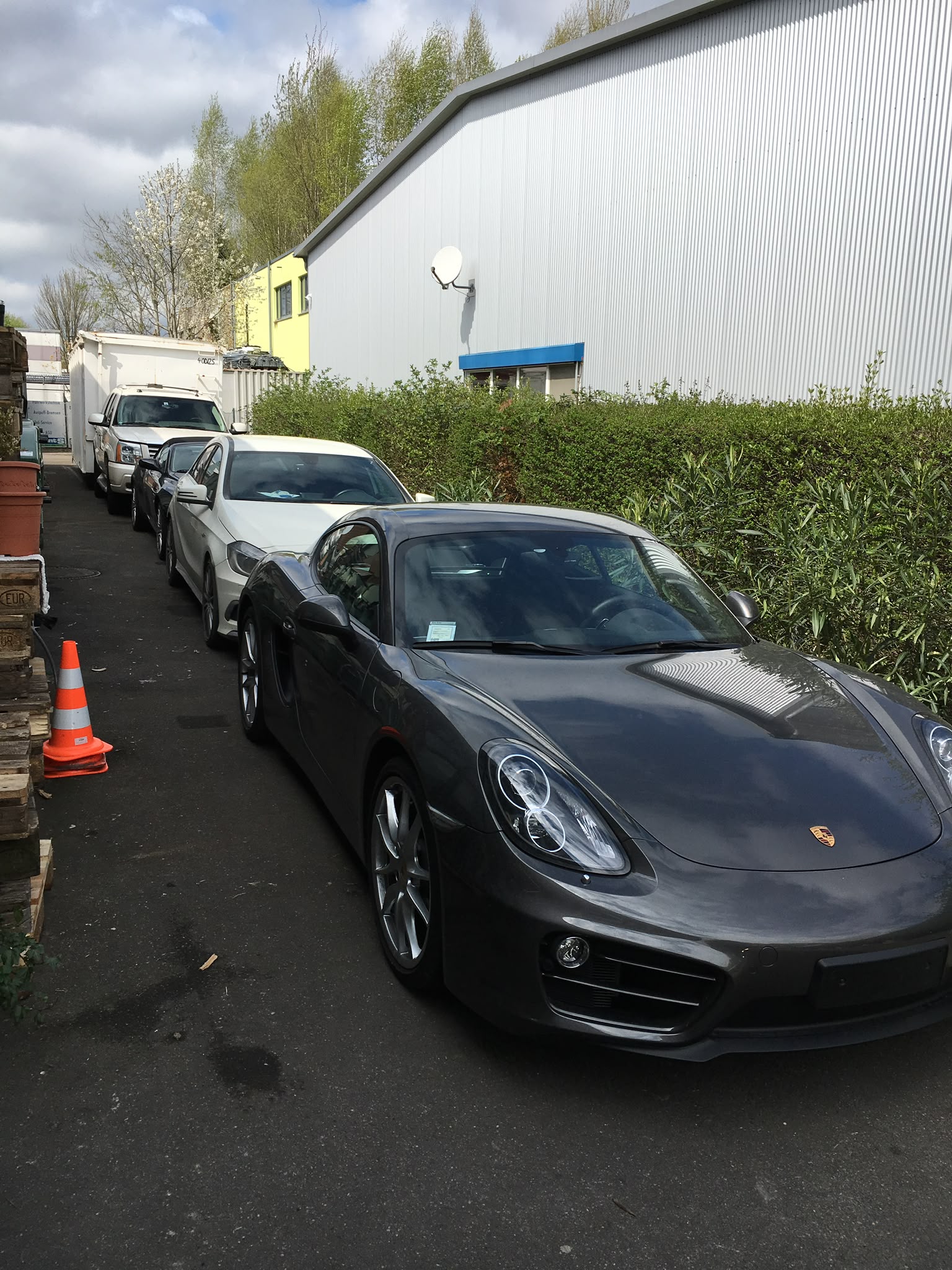 Porsche und weitere Kundenfahrzeuge bei der Lieferadresse Konstanz, Opelstraße 3 Grauer Porsche Cayman und weitere Kundenfahrzeuge auf dem Gelände der Lieferadresse Konstanz im Industriegebiet Opelstraße